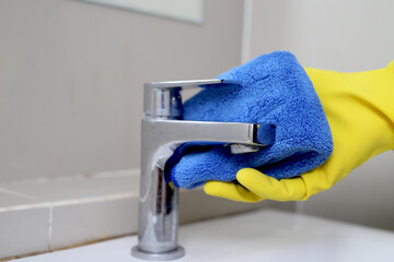 housekeeper is cleaning the faucet in the bathroom.