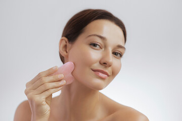 Smiling Woman Using Facial Massage Stone for Skincare and Wellness