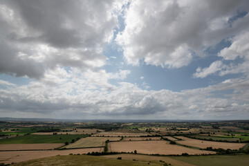 A peaceful rural scene showing a hillside path under a cloudy sky, with open views across the countryside.