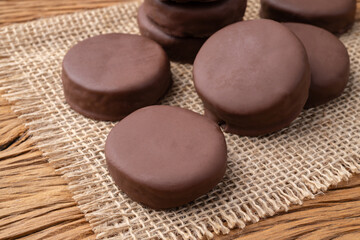 Brazilian Pao de Mel or chocolate covered honey cookies over a wooden table