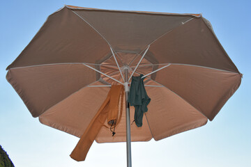 Parasol, sea, summer and holidays. 
Summer beach in Italy and orange umbrella offering shade under...