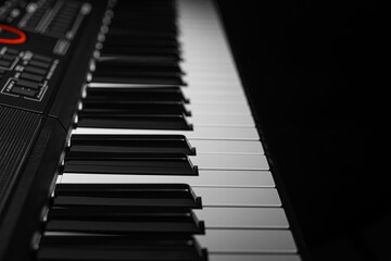 Closeup of a modern digital piano keyboard with black and white keys in a diagonal perspective on a...