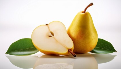 studio shot of a whole and a half of ripe yellow pear with green leaves lying on a white reflective surface