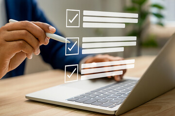 Hand Using Stylus Marking Checklist on Laptop Screen for Task Management and Productivity