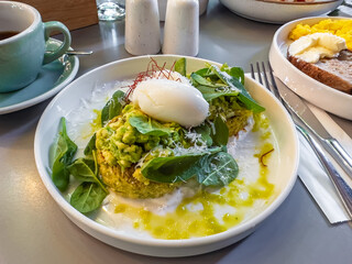 A delicious and healthy breakfast of zucchini fritters topped with smashed avocado, a perfectly...