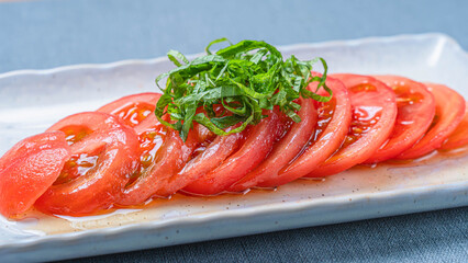 冷やしトマトの薄切りに青じそを添えた夏のさっぱり前菜