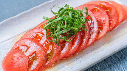 冷やしトマトの薄切りに青じそを添えた夏のさっぱり前菜