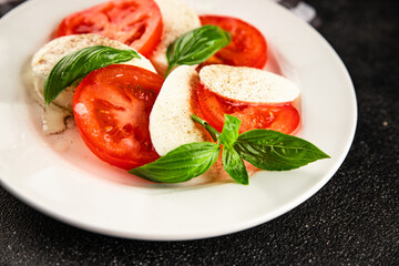 Caprese salad mozzarella and tomato, basil fresh delicious gourmet food background on the table rustic food top view copy space keto and paleo diet vegan and vegan food