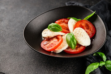 Caprese salad mozzarella and tomato, basil fresh delicious gourmet food background on the table rustic food top view copy space keto and paleo diet vegan and vegan food