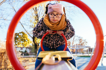 Girl with Down syndrome framed by red circle at playground