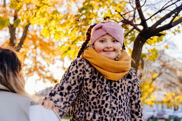 Confident girl with Down syndrome standing in autumn sunlight