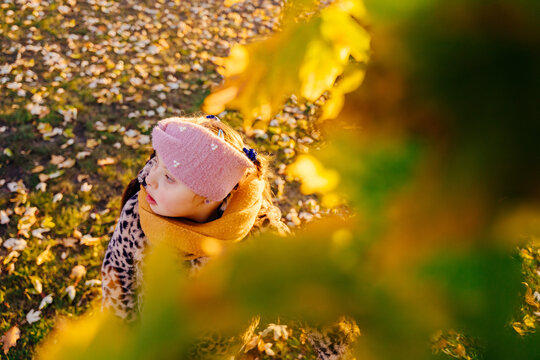 Curious girl with Down syndrome exploring autumn leaves in park