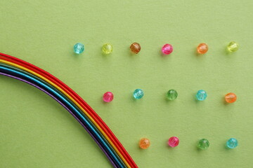 虹と罫線のようにビーズを並べた背景　背景色黄緑色