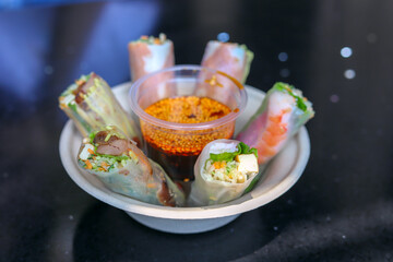 The red oil dipping sauce and spring roll food in the plate