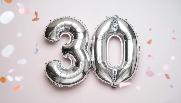 Silver balloons spelling out the number 30 against a pale pink background with confetti