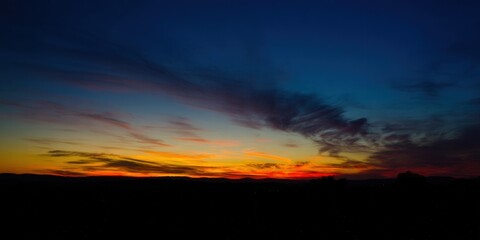 Obraz premium The sky explodes in color during a beautiful sunset over the tranquil horizon.