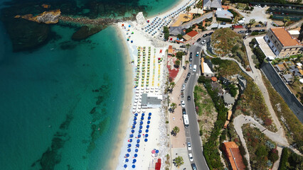 Stunning aerial view of Tropea beach, showing colorful umbrellas, turquoise crystalline sea and the...