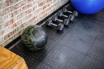 Camouflage medicine ball is resting in vector art gym corner with hex dumbbells, stability ball