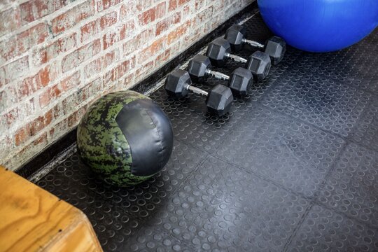 Fototapeta Camouflage medicine ball is resting in vector art gym corner with hex dumbbells, stability ball