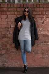 women posing in front of a brick wall