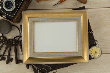 Photo frame, clock, keys, camera on wooden table