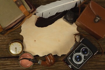 Paper piece, bag, clock and camera on table