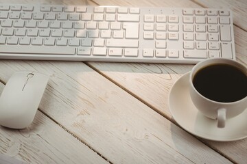 High angle view of keyboard and mouse with coffee cup