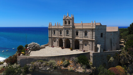 Aerial view of Santa Maria dell'Isola sanctuary on a cliff overlooking Tropea beach and turquoise...