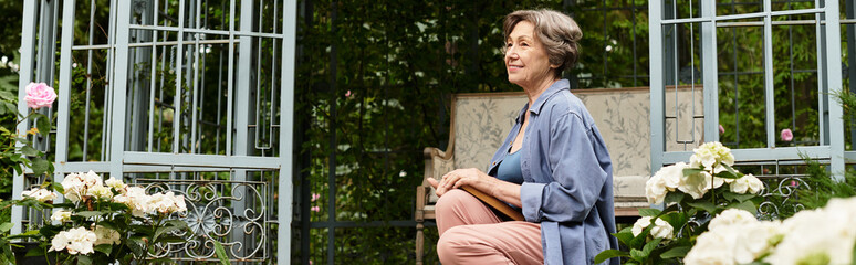 Senior woman enjoys peaceful moments in a blossoming garden filled with vibrant flowers and greenery