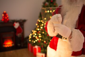 Senior Santa figure is holding transparent panel in flat design Christmas living room, copy space