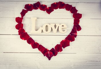 Heart shape frame with red roses petals