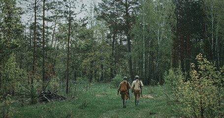 Group of Soldiers Walking Through Forest with Rifles