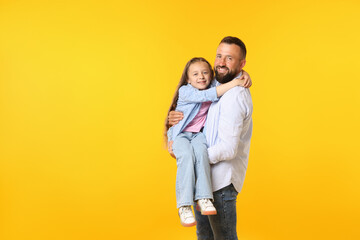 Family. Happy father and his daughter on yellow background. Space for text