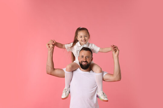 Family. Happy father and his daughter on pink background
