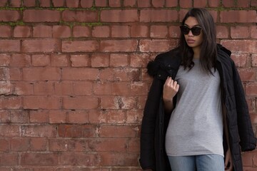 women posing in front of a brick wall