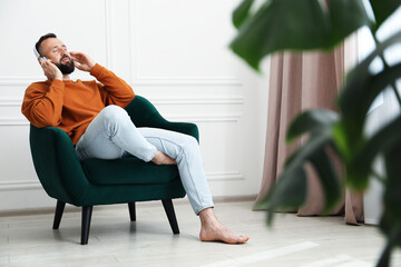 Harmony. Man listening to music in headphones at home