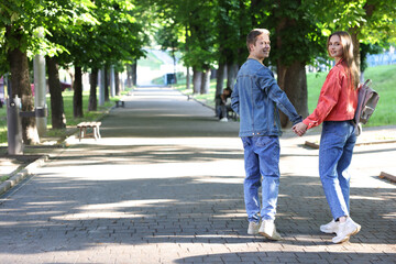 Obraz premium Lovely couple walking together in park, space for text