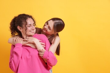 Friends hugging each other on orange background, space for text