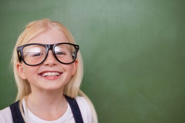 Flat design is showing girl wearing oversized glasses and smiling in front of green chalkboard