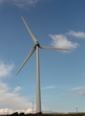 Fototapeta premium Windmill spinning against blue sky