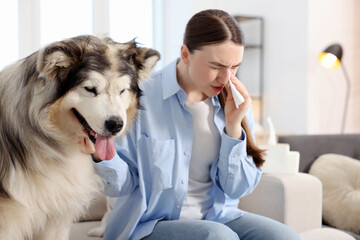 Woman suffering from allergy with her dog at home