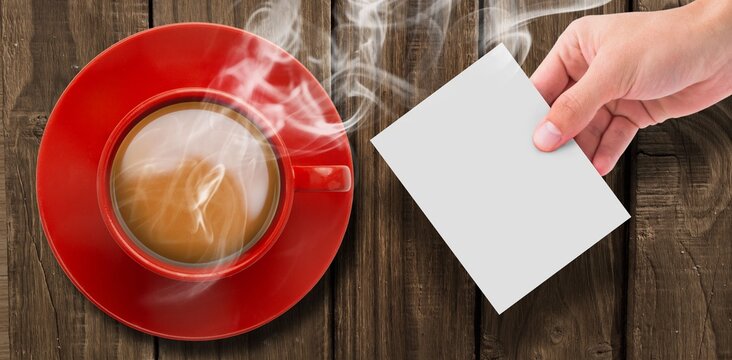 Fototapeta Overhead view of hot tea by hand holding page