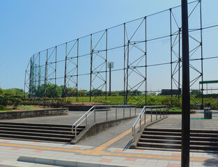 A ramp located between the concrete staircases in front of the baseball stadium.
The tactile paving has been installed for people with  visual impairment.