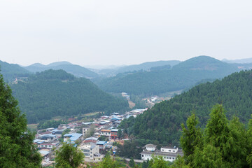 The architectural complex of Hexin Town in Deyang, Sichuan Province, China and the natural scenery of Longquan Mountain Range