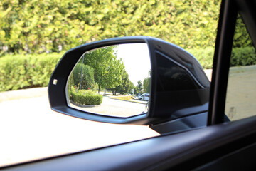 Look in the rear view mirror of a car. Side rear-view mirror. View of the outside rearview mirror...