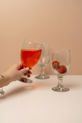 Woman's hand holding a glass of strawberry wine or juice. A scene of celebration, tasting, or a party. Cheers concept.
