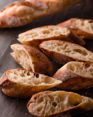 Close-up of freshly baked French baguette slices with a golden crust and airy crumb texture....