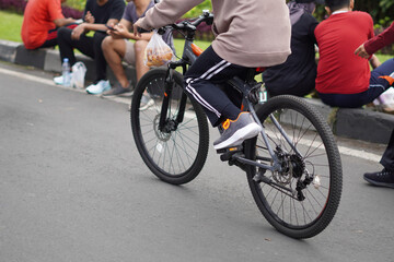 A person wearing training clothes cycling on a public road