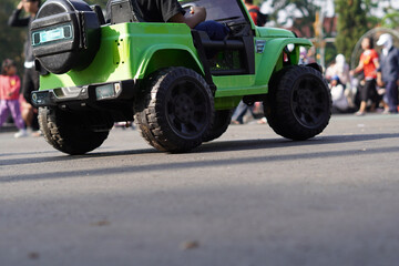 A remote control car being ridden by a child in a public place