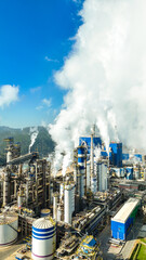 Vista vertical de uma fábrica de papel e celulose operando com caldeiras e chaminés, emitindo poluentes no ar e representando os desafios da sustentabilidade na indústria